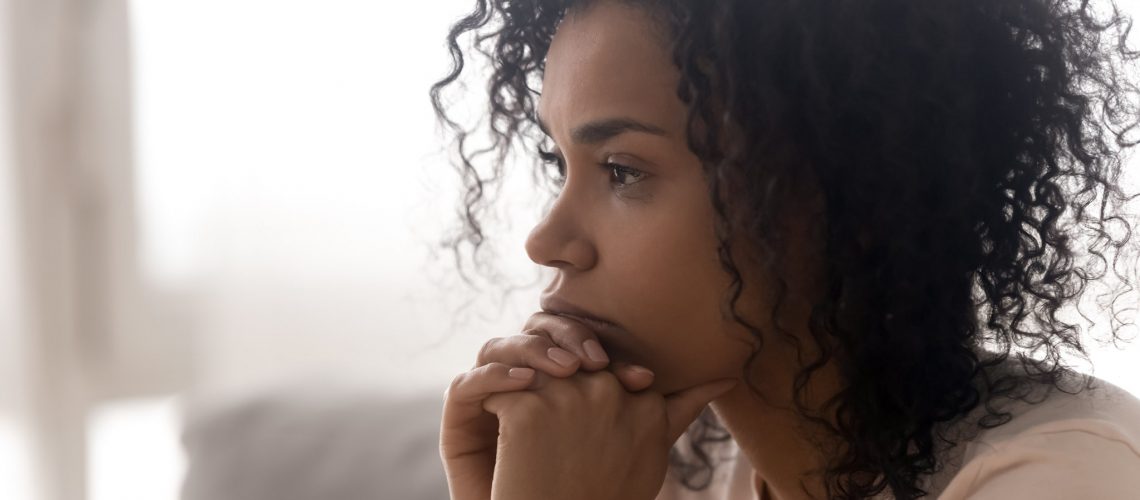 Close up side profile view of pensive young african American woman thinking of relationships problems, thoughtful black biracial female feel despair lost in thoughts consider life trouble or drama