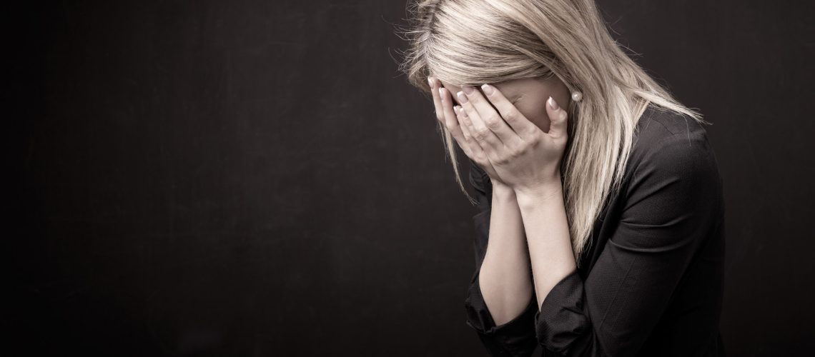 Woman holding her face in her hands